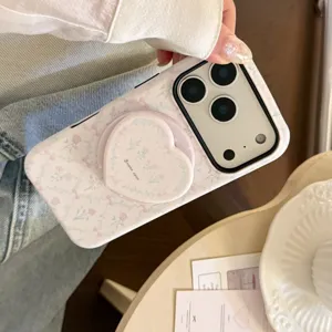Close-up of pink floral iPhone case featuring a matte heart-shaped foldable grip stand.