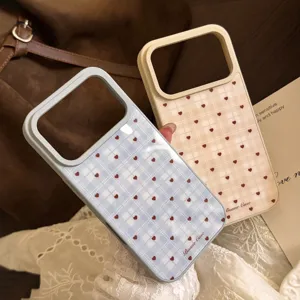 Détail de coques de téléphone à carreaux avec motifs de cœur bleu et beige en situation