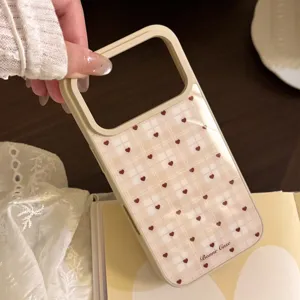 Vue détaillée d'une coque de téléphone à carreaux crème avec petits cœurs rouges