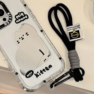 Détail d'une dragonne tressée noire et d'une coque de téléphone avec motif chat.