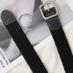 Woven elastic belt detail shot showing textured black fabric and sturdy silver metal buckle.