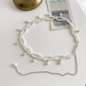 Detailed macro view of an elegant Bohemian white pearl waist chain with silver link