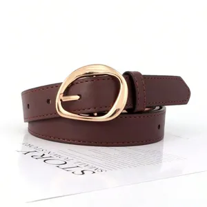 Close-up detail of retro oval gold buckle on a brown faux leather belt for women