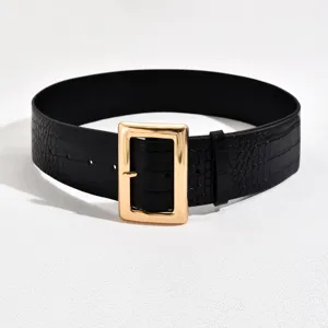 Close-up detail of black crocodile pattern belt featuring a shiny gold square buckle.