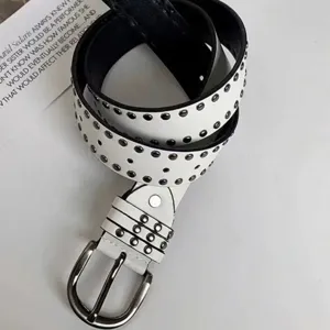 Close-up of white leather belt with black rivets and polished metal buckle detail