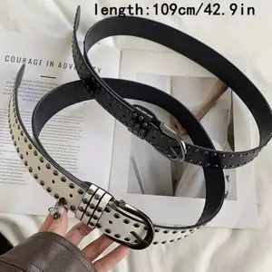 Macro view of black and white vintage leather belts with decorative metal rivet studs