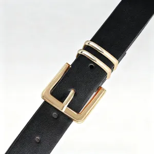 Close-up detail of women's black leather belt featuring a sleek gold metal pin buckle and dual loops.