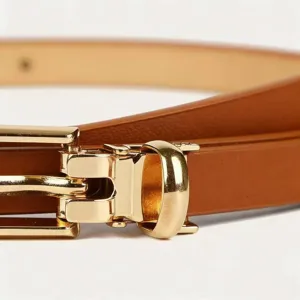 Detailed close-up of a minimalist women's thin brown leather belt with a polished gold pin buckle.