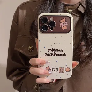 Macro detail of cute cartoon teddy bear and ink splatter pattern on a cream iPhone case