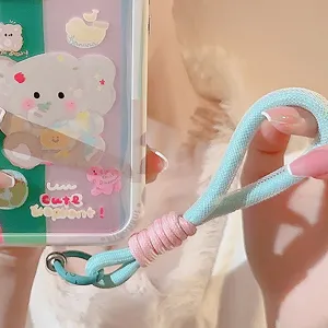 Détail de près d'une dragonne de téléphone tissée en couleurs bleu et rose contrastées