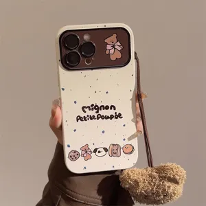 Macro view of the cute bear illustration and fuzzy lanyard charm on the phone case