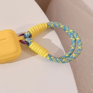 Vue macro détaillée d'une dragonne de téléphone tressée élégante en bleu et jaune