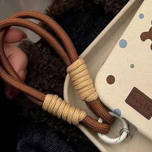 Gros plan macro d'une dragonne de téléphone tressée marron et beige avec anneau