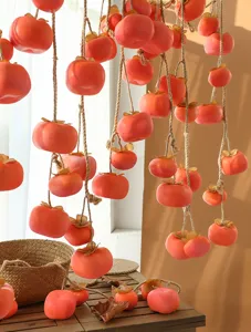 Detailansicht von gefrosteten künstlichen Kakischnüren für die herbstliche Wohndeko.