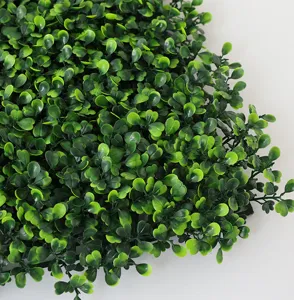 Close up view of dense artificial Milan grass wall panel, showing detailed green leaf texture.