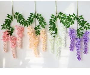 Realistic artificial hanging wisteria flower vines in multiple colors on white wall