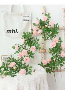 Elegante künstliche rosa Pfingstrosenranke, dekorativ über eine rustikale Holzleiter hängend