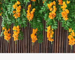 Dettaglio di rampicanti di fiori artificiali arancioni appesi davanti a una recinzione di bambù
