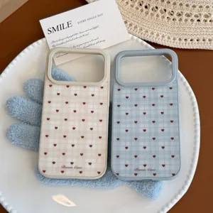 Vue détaillée des coques iPhone à carreaux beige et bleu avec motifs de cœurs rouges