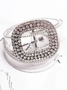 Detalle de cerca de un cinturón de PVC transparente con una hebilla de strass brillante