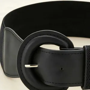 Close-up of a black wide elastic belt featuring a prominent round buckle design