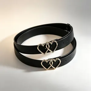 Detail view of stylish black PU leather belt featuring shiny gold interlocking heart buckles.