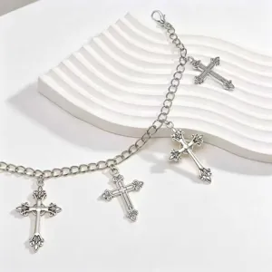 Detailaufnahme der silbernen Metallkette mit mehreren vintage gotischen Kreuz-Anhängern.