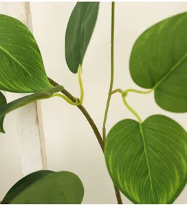 Detailed close-up showing realistic vein textures on artificial green vine leaves.