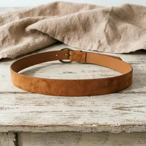 Detailed view of the vintage caramel suede leather belt featuring a bronze metal buckle.