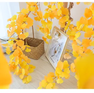 Vista dettagliata di viti artificiali di foglie di ginkgo gialle in un decoro domestico rustico.
