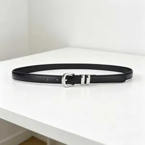 Close-up view of a minimalist black thin leather belt with a polished silver metal buckle.