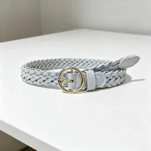 Detailed view of a light blue braided women belt with a gold round buckle for stylish outfits.