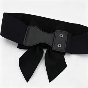 Close-up of black elastic waist belt with large bow decoration and metal snap buttons
