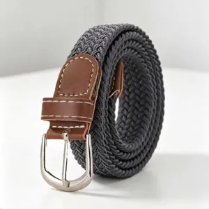 Close-up van een donkergrijze elastisch gevlochten riem met bruine lederen accenten.