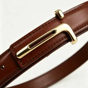 Close-up detail of women's brown leather belt with minimalist gold-tone metal buckle.