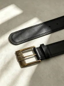 Dettaglio di cintura da uomo in vera pelle con fibbia quadrata in bronzo e doppie cuciture.