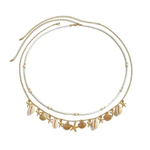 Boho beach multi-layer waist chain with gold tone, white beads, shells and starfish charms.