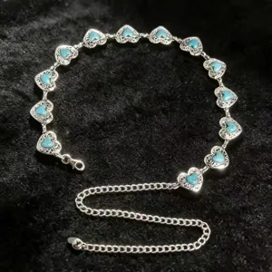 Vintage heart metal waist chain with turquoise-style stones on black background