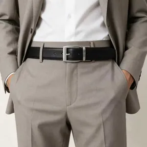 Close-up of black leather belt with silver buckle worn with a professional grey suit.