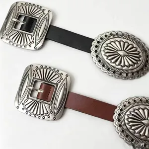 Detail shot of Western vintage belts with engraved distressed silver buckles.