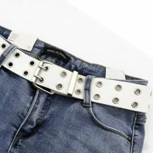 Détail d'une ceinture blanche à double rangée d'œillets portée sur un jean bleu