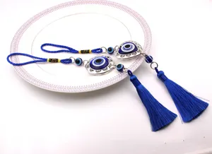Detalle de adornos colgantes de ojo turco azul con borlas largas y marcos plateados