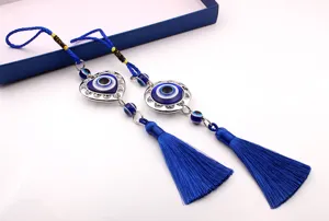 Primer plano de borlas azules del mal de ojo con dijes de corazón hueco y metal redondo