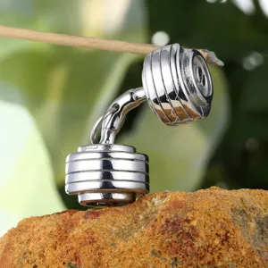 Macro detail of a high-polished stainless steel dumbbell pendant on natural rock background