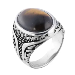 Close-up detail of a vintage titanium steel ring featuring an oval tiger eye stone.