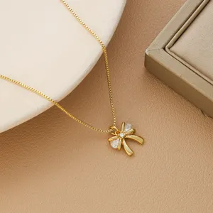 Close-up of elegant gold-plated bow pendant necklace with sparkling stones