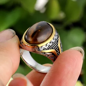 Close-up detail of vintage titanium steel ring featuring an oval tiger eye gemstone