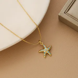 Detail view of a gold plated starfish pendant necklace featuring sparkling blue crystals