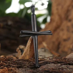 Macro detail of a black titanium steel baseball bat cross pendant on natural bark.