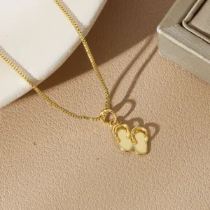 Close-up of a gold-plated necklace featuring a creative flip-flop charm pendant